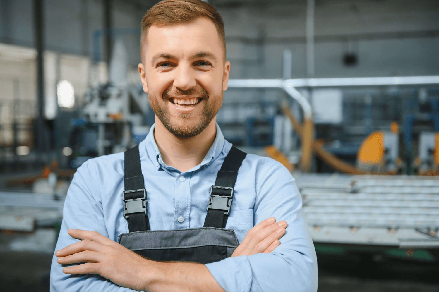 Lächelnder Kuhlmann-Mitarbeiter in Arbeitskleidung in der Werkhalle